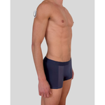 Side view of model wearing SilkCut grey trunks demonstrating stretch fit